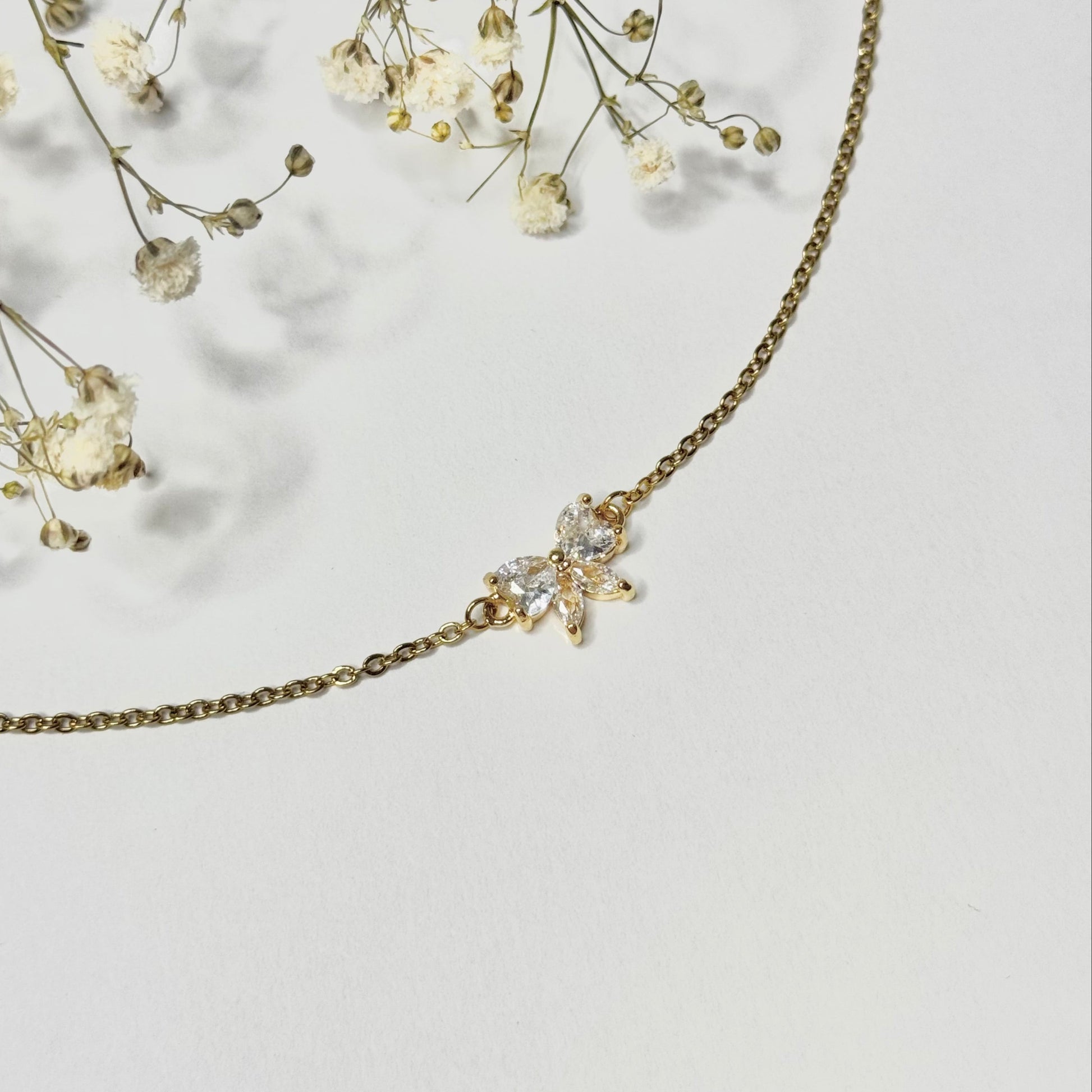 Collier doré en acier inoxydable et pendentif noeud en oxyde de zirconium fermoir mousqueton. Bijou élégant et minimaliste